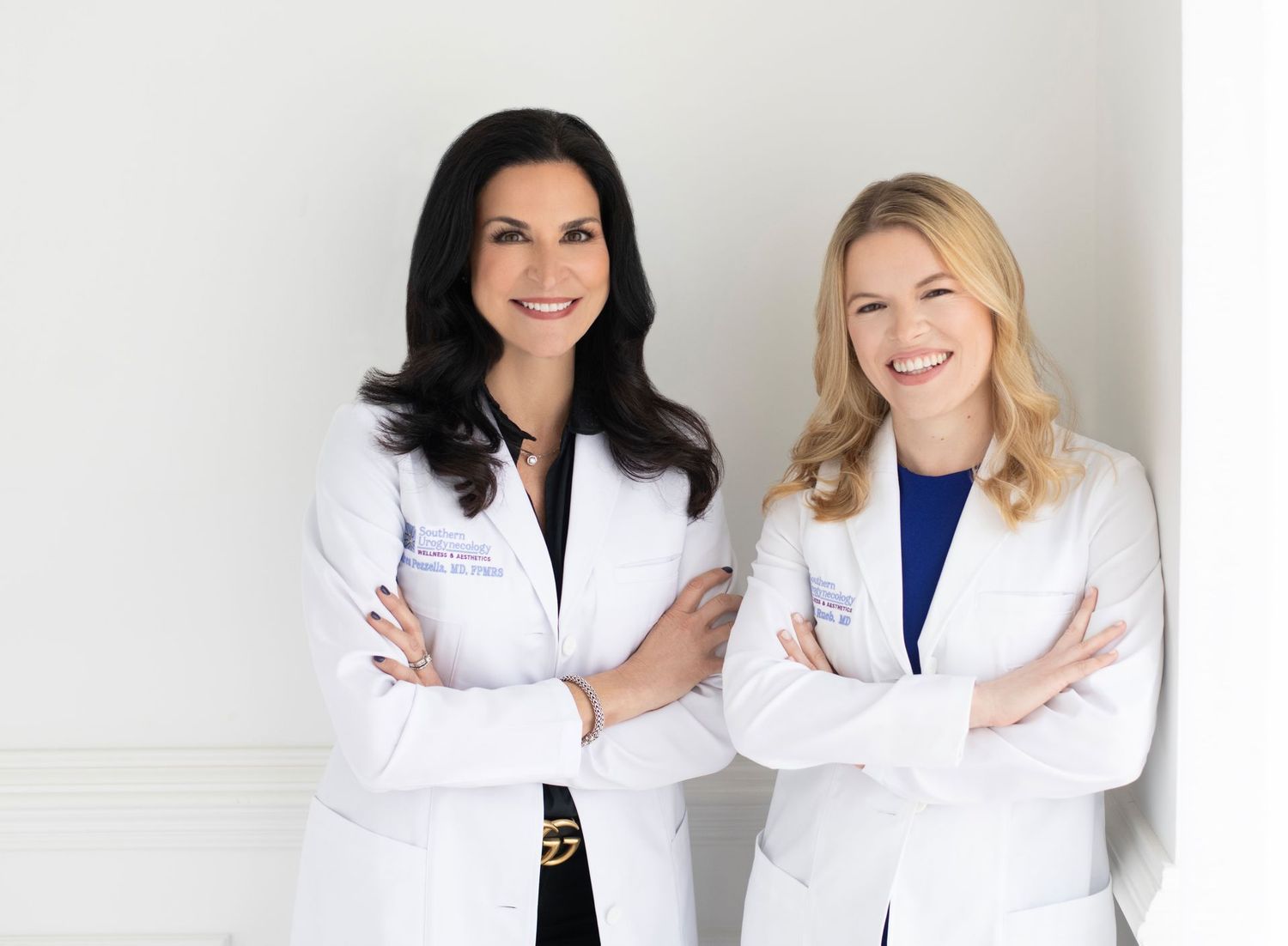 Two female doctors posing in professional attire.